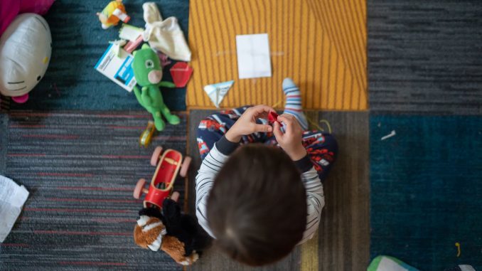 top view photography of toddler playing with toy